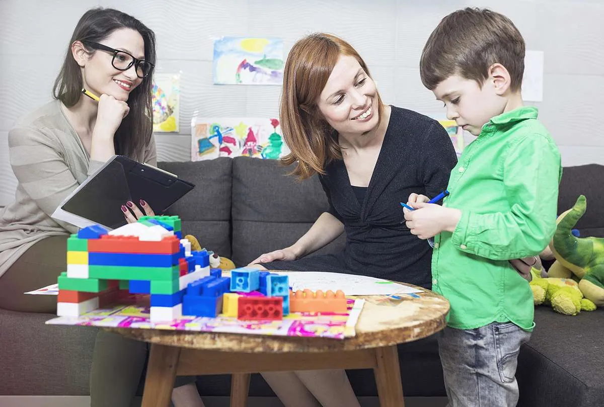 Therapist working with a child and parent at Acorn Autism